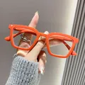 Detailopname van stijlvolle leesbril met oranje dik montuur en anti-blauw licht lenzen. - +1.00 Dioptrie / Oranje