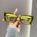Dichtbij van een stijlvolle olijfgroene vierkante leesbril vastgehouden door verzorgde hand - +1.00 Dioptrie / Groen Frame