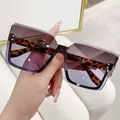 Dettaglio di occhiali da sole rimless oversize con lenti sfumate e aste leopardate. - Montatura Oro Sfumato Tè a Blu