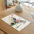 Linen placemat featuring a colorful watercolor hummingbird design on a wooden dining table - 32x45cm / Multicolor Hummingbird (7003-22)