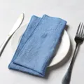 Premium blue slub cotton fabric napkin with merrow stitched edges on white plate - 32x32cm / Medium Blue