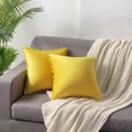 Bright yellow velvet cushion covers with cute pom poms decoration on a grey sofa - 45x45cm / Bright yellow