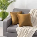 Soft mustard yellow Dutch velvet cushion covers with elegant pom-pom trim on a grey sofa - 45x45cm / Coffee