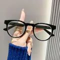 Detailopname van een modieuze zwarte leesbril met rond montuur en blauwlichtfilter - +1.00 / Zwart Frame