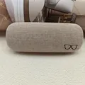Schützendes Brillenetui mit Leinentextur und minimalistischer schwarzer Stickerei - Camel