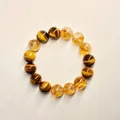 Nahaufnahme eines Armbands aus gelbem Citrin und Tigerauge-Perlen auf neutralem Grund - Tigerauge und Turmkristall-Stil / 10mm