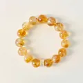 Nahaufnahme eines gelben Citrin-Perlenarmbands mit einem goldenen Kristall-Abstandshalter. - Gelber Kristall Stil / 12mm