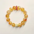 Detailansicht eines gelben Citrin-Armbands mit rotem Abstandshalter und Goldanhänger - Erdbeerkristall-Friedensschnallen-Stil / 12mm