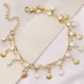 Macro view of a gold-layered necklace featuring sea shell charms and clear crystals - Double Layer Shell White Rhinestone Bracelet / White