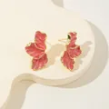 Vista dettagliata di orecchini a foglia di acero rosa con bordi dorati e smalto. - Rosa