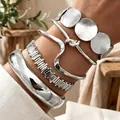 Dettaglio di bracciali in metallo argento a strati con design lisci, ondulati e martellati - Modello 6251 Set Argento