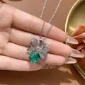 Dettaglio di una collana con ciondolo a fiocco e una pietra verde smeraldo - Collana con ciondolo / Collana Verde Smeraldo