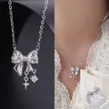 Detailed macro and model view of a silver bow pendant necklace with star charms. - White