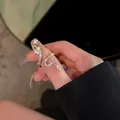 Primo piano dettagliato di un anello a forma di serpente con zirconi brillanti e chiari - Stile serpente avvolto in strass (5667501)