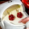 Primo piano di eleganti orecchini vintage con cristalli rossi in scatola grigia - Rosso