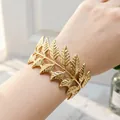 Dettaglio della complessa trama foglia oro dell'elegante bracciale a polsino aperto. - Foglia
