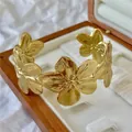 Elegante bracciale rigido a fiori dorati con petali testurizzati in una scatola per gioielli - Fiore Oro