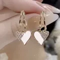 Elegant heart-shaped drop earrings with shimmering crystals and gold twist hoops - White
