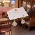 Primo piano di eleganti orecchini a sfera in cristallo vintage con ganci color oro - Bianco