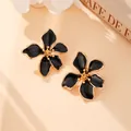 Eleganti orecchini a lobo a fiore in smalto nero con bordi e centro in tono dorato. - Nero