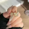 Vista detallada de un anillo de mariposa y serpiente en oro con pavé de piedras. - Estilo Mariposa de Zirconia / Abierto Ajustable