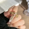 Detalle macro de anillo vintage de flor de lis con piedras rosas y motivo de serpiente - Estilo Flor de Lis Circonia Rosa / Abierto Ajustable