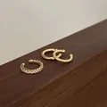 Detailansicht von drei goldenen Earcuffs mit Steinen und gedrehtem Metall-Design - 14K Gold [3-teiliges Set]