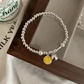 Détail d'un bracelet en argent 925 avec perles et breloque smiley jaune - Bracelet Perle Jaune avec Smiley et Clochette (SL0750)