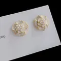 Vista macro dettagliata di eleganti orecchini a camelia bianca con accenti di perle lucide - Orecchini a lobo / Bianco