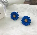 Dettaglio ravvicinato di orecchini a lobo a margherita blu con centro oro intrecciato - Blu