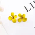 Dettaglio di orecchini a lobo a forma di fiore giallo con centro dorato glitter - Giallo