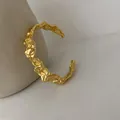 Detailed shot of a gold irregular textured open cuff bracelet with molten metal finish - Irregular Texture Style (SL0513) / Gold