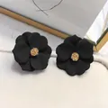 Orecchini a perno a fiore nero opaco con pistillo dorato testurizzato elegante - Nero