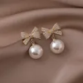 Orecchini a lobo a fiocco eleganti con cristalli scintillanti e pendenti di perle. - fiocco con perline / Bianco