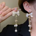 Detailansicht eleganter langer Quastenohrringe mit weißen Schleifen und Perlenverzierung. - Schleife Mehrschichtige Künstliche Perle Quaste Ohrstecker (E3180) / Weiß