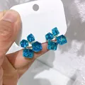 Vista macro di orecchini a lobo 3D in zircone blu con elegante design a cubetto di zucchero - Blu