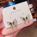 Primo piano di eleganti orecchini a farfalla con micro-pave di zirconi e ago in argento S925 - Stile Farfalla (Nero) / Nero