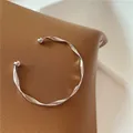 Elegant silver wavy cuff bracelet with an adjustable open design and smooth finish. - Silver