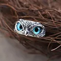 Primo piano dettagliato di un anello a gufo in argento vintage con occhi blu vivaci - Occhio Blu / Argento Antico