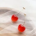 Eleganti orecchini a ciliegia rossi con steli dorati su morbido tessuto a rete bianca. - Taglia L / arancio-rosso