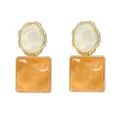Dettaglio di orecchini geometrici con resina arancione ed effetto increspatura - Bianco + Giallo