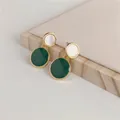 Detailed view of elegant round oil-drop earrings in green and cream white with gold frames. - Green