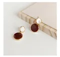 Detail showing the burgundy and white enamel finish on geometric round earrings. - Red