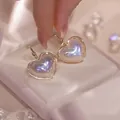 Detailed close-up of iridescent mermaid pearl heart earrings with elegant gold trim - Mermaid Iridescent Heart Stud Earrings (E2287 Gold)