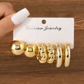 Detailed macro view of a 3-pair gold earring set featuring hoop and twisted designs - Smooth Spherical Round Tube Collection (TZ003) / 3 Pairs Set / Gold