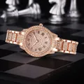Detailansicht einer luxuriösen Damenuhr in Roségold mit Strassbesatz und römischen Ziffern - Silberne Uhr mit römischem Zifferblatt / Silber