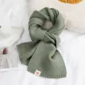 Warme saliegroene gebreide wintersjaal met 'warm-hearted' label in een zachte setting - Matchagroen