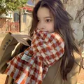 Stylish orange and white checkered cashmere-like scarf worn by a model in autumn sun. - 70-200cm / Little Windmill Star Red Plaid