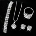 Nahaufnahme eines luxuriösen silbernen Schmucksets mit funkelnden Strasssteinen auf Schwarz - Silber Zweireihiges Armband + Silber Quadratische Halskette Ring Ohrringe Vierteiliges Set