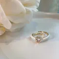 Macro view of a delicate gold heart ring featuring pink crystal and white enamel details - Pink Heart (J2906)